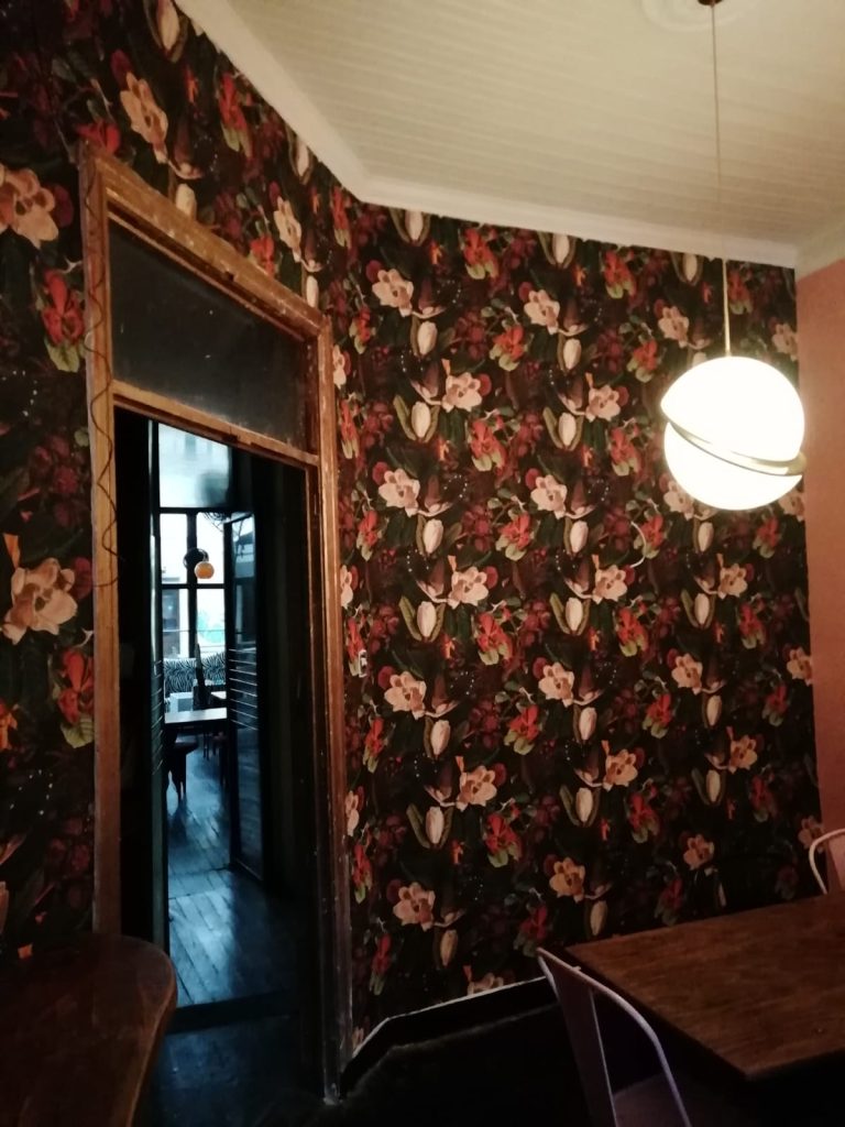 Instalación Papel Mural Decorativo flores oscuras y coloridas en tonos rojos, rosados y blancos sobre un fondo oscuro